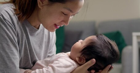 A caring mother soothing her baby girl to sleep with gentle words and loving eye contact at home, demonstrating dedication and affection in a nurturing environment