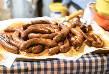 grilled meat sausages close-up on a checkered tablecloth oktoberfest appetizer