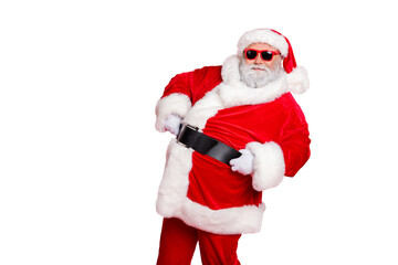 Portrait of his he nice attractive cheerful cheery content bearded Santa showing eve noel festive festal mood holding belt isolated over bright vivid shine red background