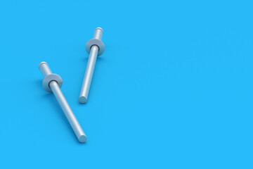 Two blind rivets on blue background. Fasteners for repair. Workshop accessories. Construction equipment. Copy space. 3d render