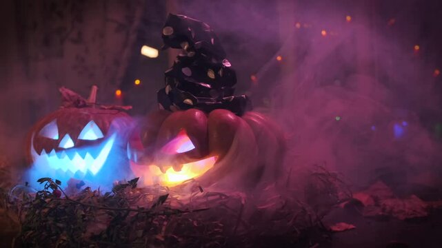 Halloween party background, creepy two carved pumpkins with light inside rotate in smoke lying on threshold close-up, among dry foliage and garlands autumn decorations.