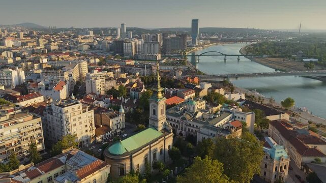Flying over Cathedral of St. Michael in Belgrade, Serbia. Aerial shot of old town and river embankment with bridges before sunset, Belgrade