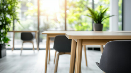 Fototapeta premium Spacious and bright office with simple wooden furniture, large windows providing natural light, blurred background of desks and chairs, modern minimalist workspace