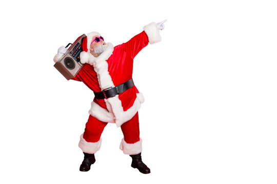 Full length profile side photo of funny santa claus raise his arms dance wear stylish trendy eyewear eyeglasses hat headwear isolated over red background