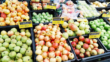 Abstract blur image of fruits, apples in boxes on defocused supermarket shelves. Retail industry. Grocery store. Greengrocers. Mart. Local farmers market. price. Food Supplier. Consumerism. Inflation