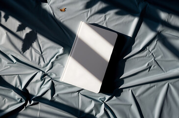 White Book on Wrinkled Fabric Under Sunlight