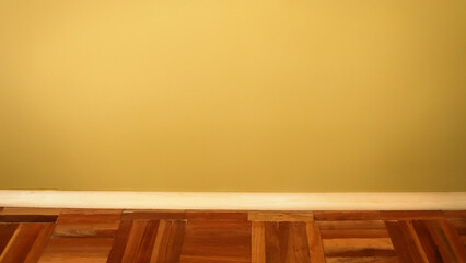 A minimalist banner featuring a section of an olive-colored wall with a wooden parquet floor and...