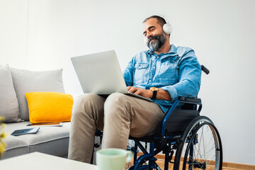 Man in Wheelchair Using Laptop and Headphones at Home