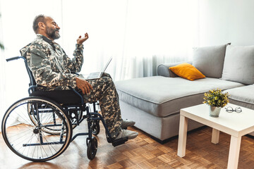 Veteran in Wheelchair Relaxing at Home with Laptop