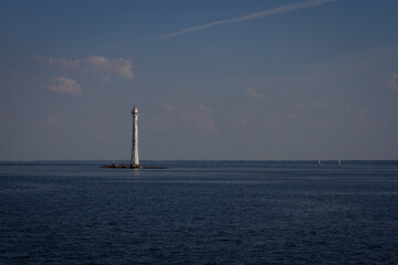 View of the lighthouse and the sea illuminated by the sun and clouds