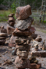 Stone on stone stacked on top of each other in the sun on a blurred green background of grass