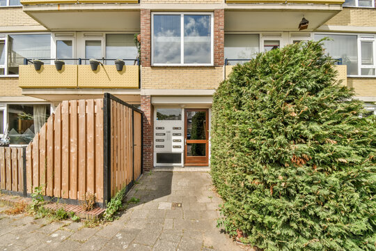 Suburban townhouse with wooden fence and green shrubs
