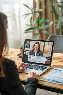 Virtual recruiter conducting interviews via video call, reviewing resumes on laptop, professional background