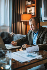 Fototapeta premium Virtual recruiter conducting interviews via video call, reviewing resumes on laptop, professional background