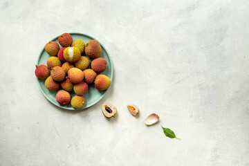 Juicy fresh lychee tropical fruit with cut in half and green leaves. Tropical fruit background