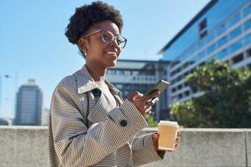 Young Woman Enjoying Coffee and Smartphone in Modern City