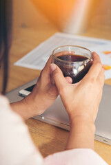 Vertical Close up hands of woman sitting office desk holding sweet coffee cup relax and enjoy with happy time. Vertical Horizon Hot coffee mug in hand. Woman hand holding coffee cup relax at office