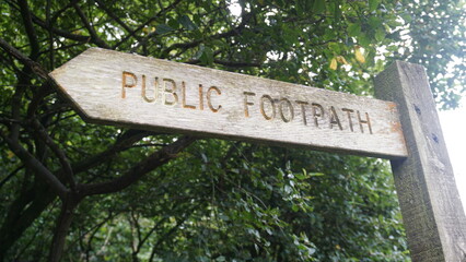 Rustic wooden sign signalling a public footpath