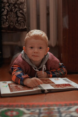 red haired child looking at photo album in old retro style apartment