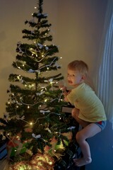 The ginger baby stuck out his tongue and tried to climb the tree