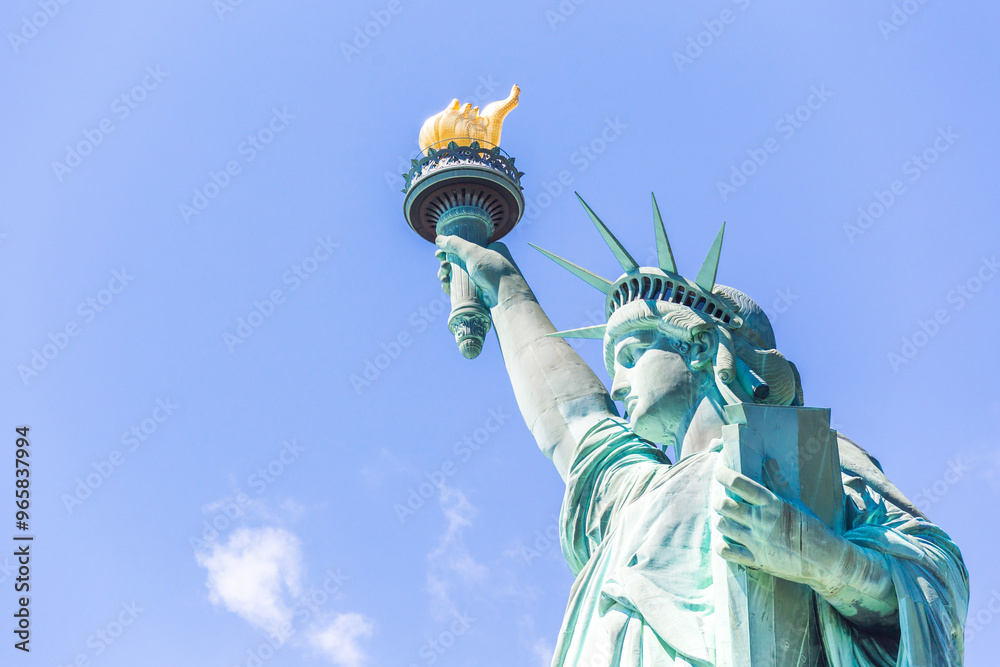 Wall mural close view of the statue of liberty over blue sky