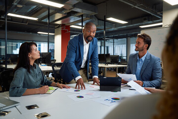 Group of multiracial business people in businesswear talking and gesturing during meeting in office