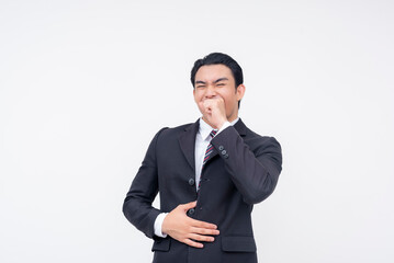 A young cheerful asian business executive in a suit and tie chuckling, trying to cover his laughter with his hand. Isolated on a white background.