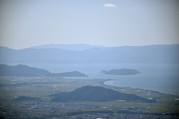 霊仙山からの霞んだ琵琶湖の眺め、手前中央に荒神山、その右上に沖島
