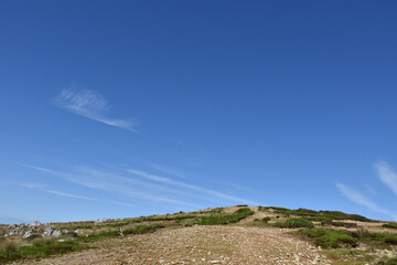 青い空、丘の向こうに筋雲が流れる。