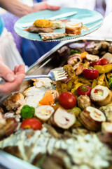 Delicious buffet spread featuring assorted grilled meats, vegetables, and garnishes at a summer gathering in a vibrant outdoor setting