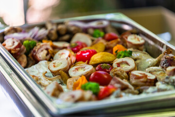 Elegant platter of assorted meats and colorful vegetables served at a festive gathering during a sunny afternoon