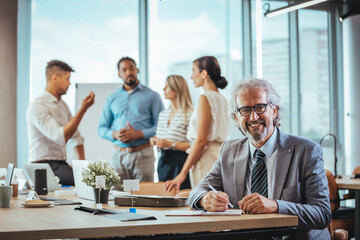 Confident Businessman Leading Team Meeting in Modern Office