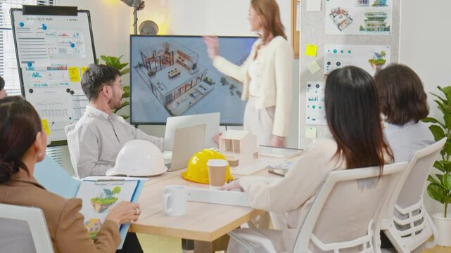 Asian professional architect is presenting a 3D house design concept to a team of colleagues during a meeting in a modern office environment. Business meeting concept
