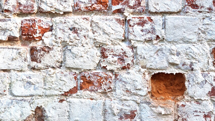 Ancient ruined brick wall with paint residue. Brick weathering. Selective focus