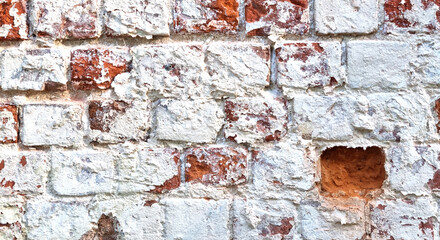 Ancient ruined brick wall with paint residue. Brick weathering. Selective focus