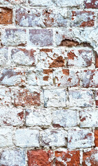 Ancient ruined brick wall with paint residue. Brick weathering. Selective focus