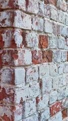 Ancient ruined brick wall with paint residue. Brick weathering. Selective focus