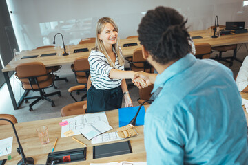 Obraz premium Colleagues Shaking Hands During Office Meeting at Conference Table