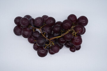 Seedless red grapes come in bunches with many seeds.