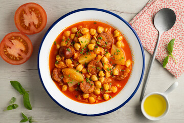 Delicious dish of braised chickpeas with spicy chorizo. Top view food table.