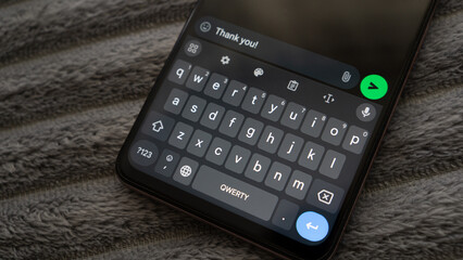 Sending message with text Thank you!, closeup. Send sms with smartphone. Thanksgiving day