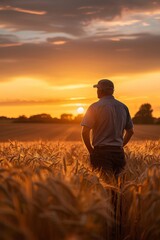 Farmer standing proudly in a vast field of wheat at sunrise