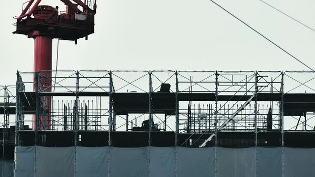 曇り空の下のマンション工事現場の風景