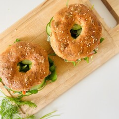 Homemade Bagels with Sesame Seeds, Salmon, Cucumber and Herbs Served