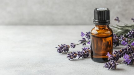 Bottle of essential oil and lavender flowers on light stone table