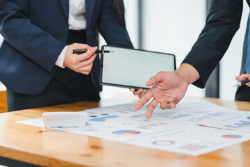 Collaborative business meeting with charts and tablet