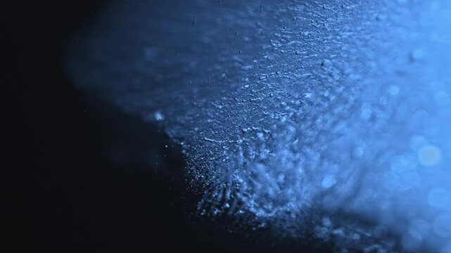 Abstract water backround with piece of ice moving. Chaotically moving glowing dust particles in water. Timelapse. Ice floe isolated. Blue light glowing. Underwater. Textured ice surface	