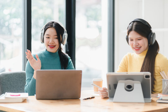 Engaged women using laptops and tablets, enjoying productive moment together.