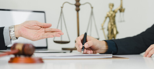 Legal consultation with gavel and scales of justice in background.