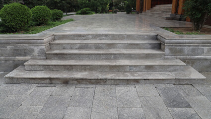 empty Pedestrian ladder. Empty concrete stairs,staircase. tiled gray flooring in perspective. tile grey floor. summer city park with trees and bushes. Batumi, Georgia.